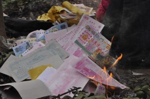 Foto prosesi pembakaran uang untuk leluhur saat Imlek oleh Arzia Wargadiredja.
