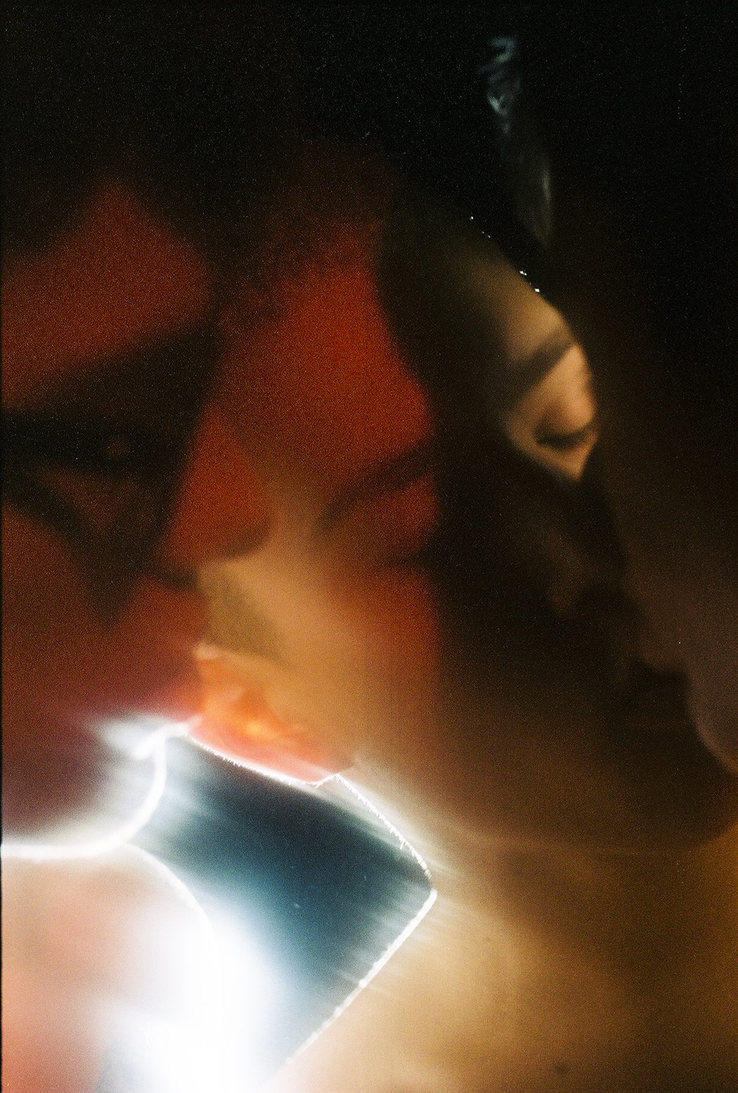 Drei junge Männer küssen sich im gleißenden Licht