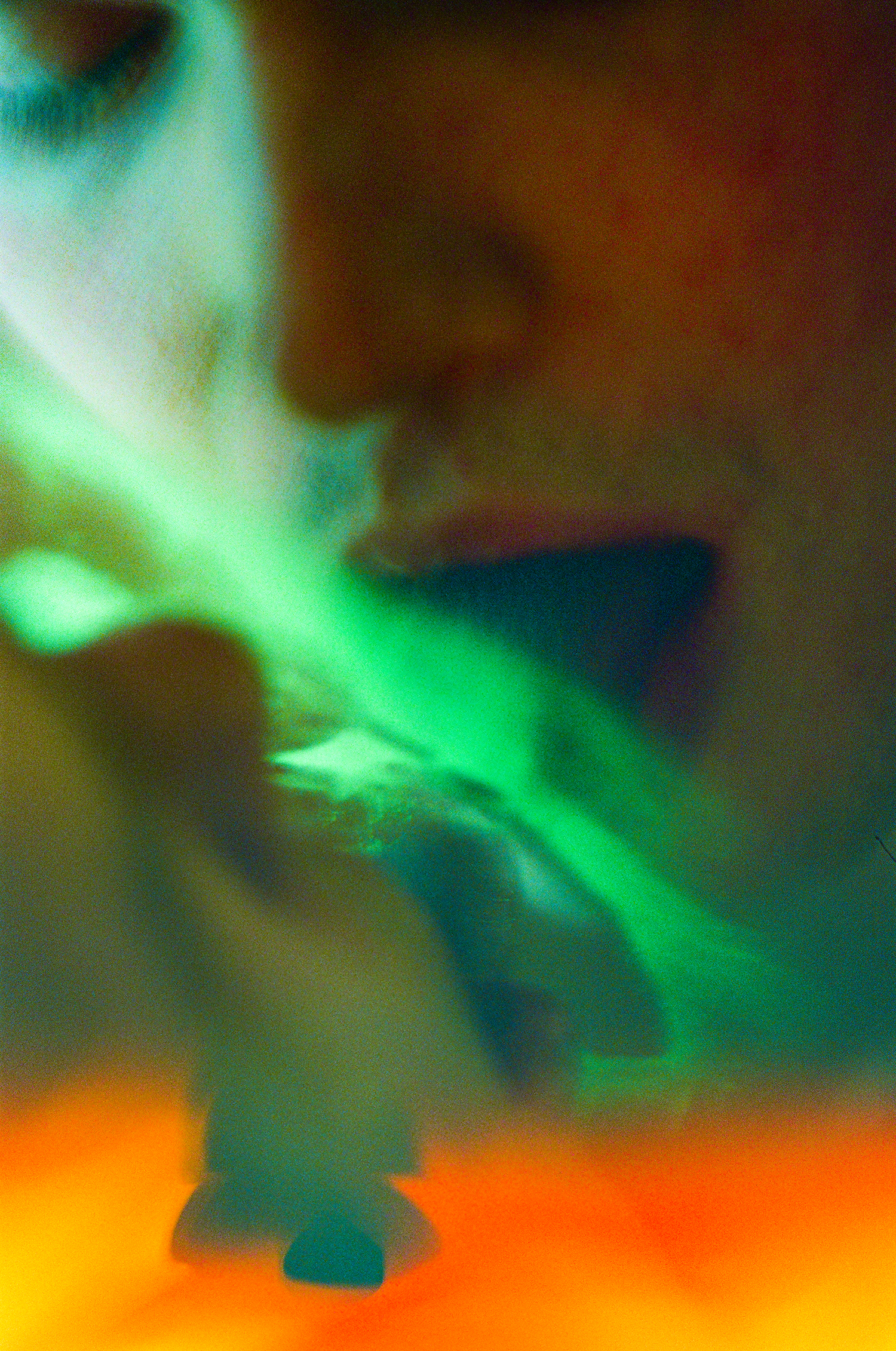 Nahaufnahme zweier küssender Münder mit einem nicht klar erkennbaren grünen Material zwischen ihnen