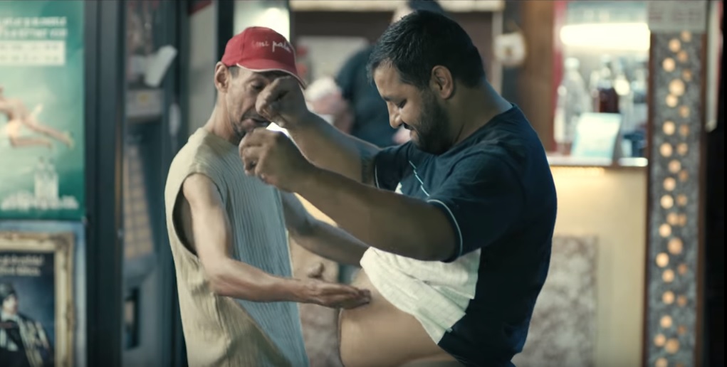 un bărbat îl bate pe altul pe burtă