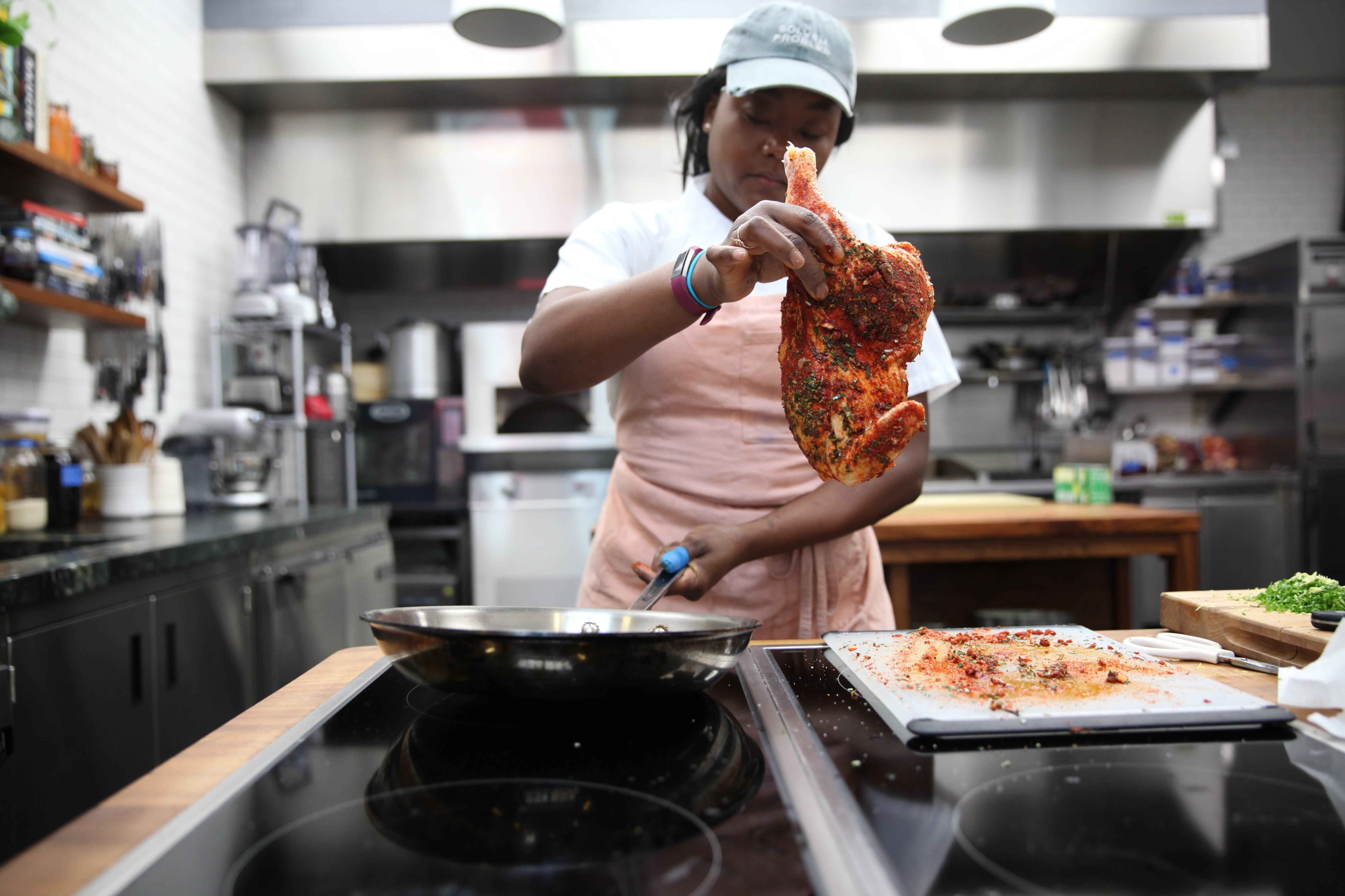 Ashley Eddie putting chicken into a frying pan