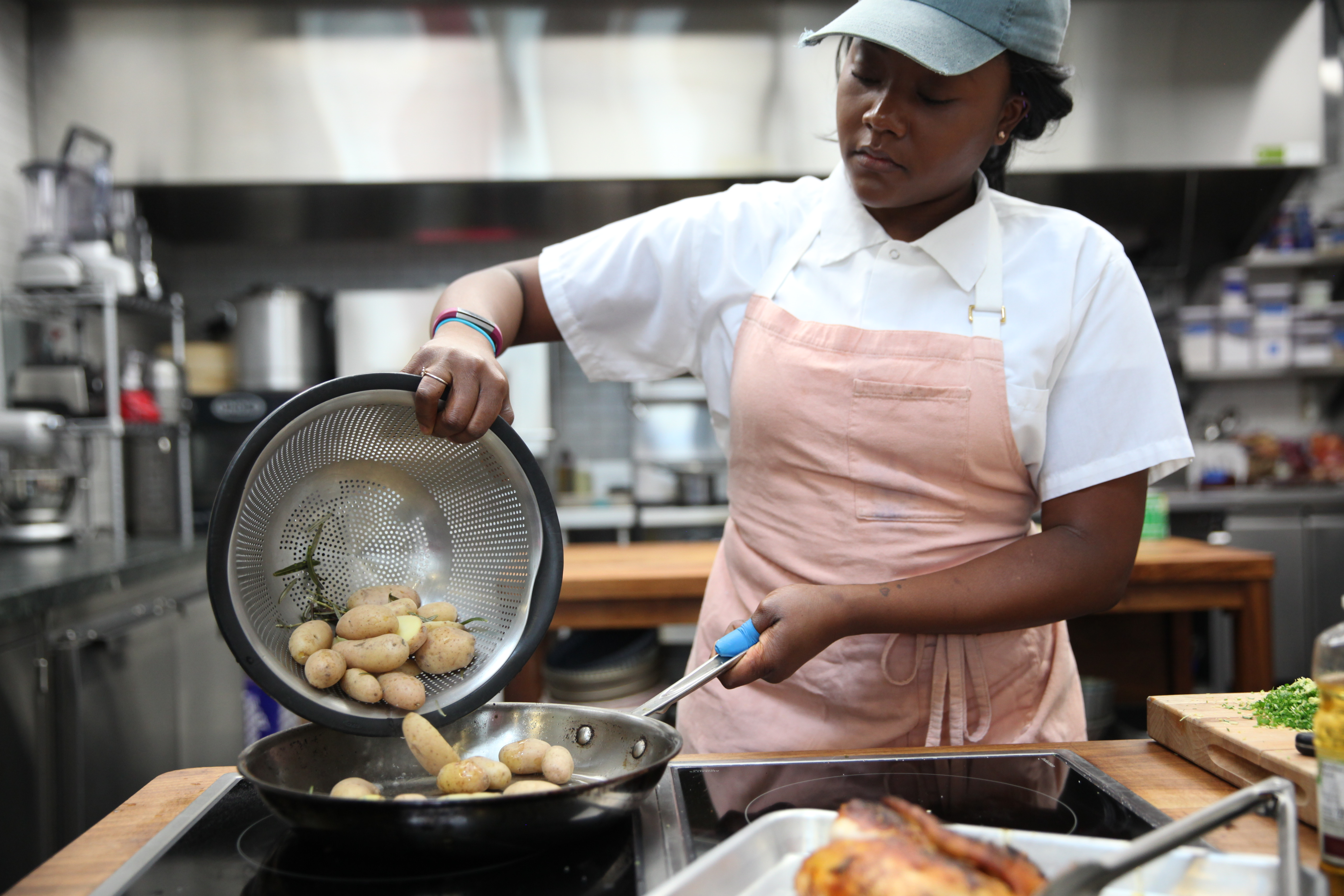 Ashley Eddie adding potatoes to skillet