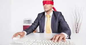 Geblinddoekte man achter een computer