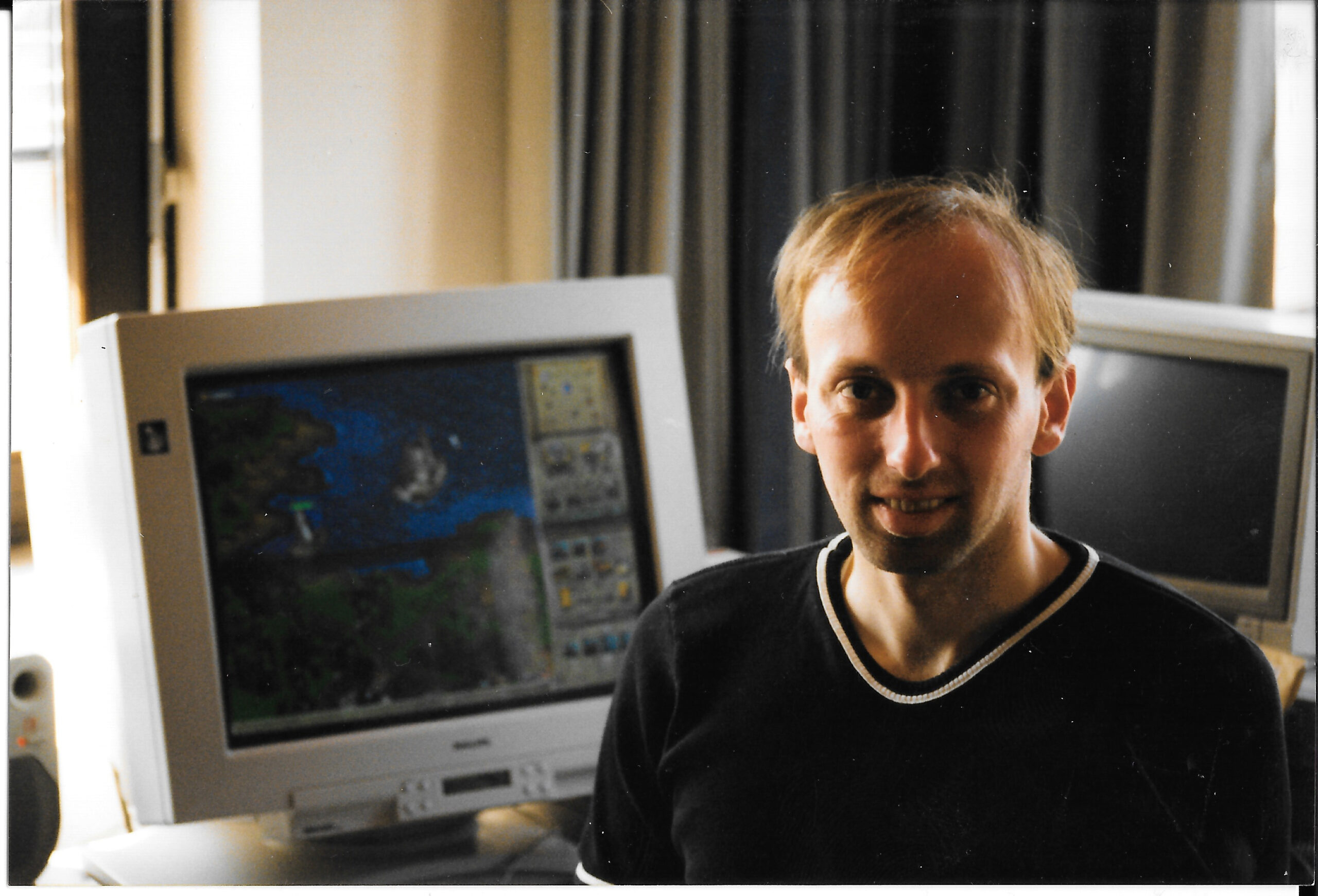 Altes Foto von Wilfried Reiter. Er sitzt vor einem Röhrenmonitor auf dem Anno 1602 zu sehen ist