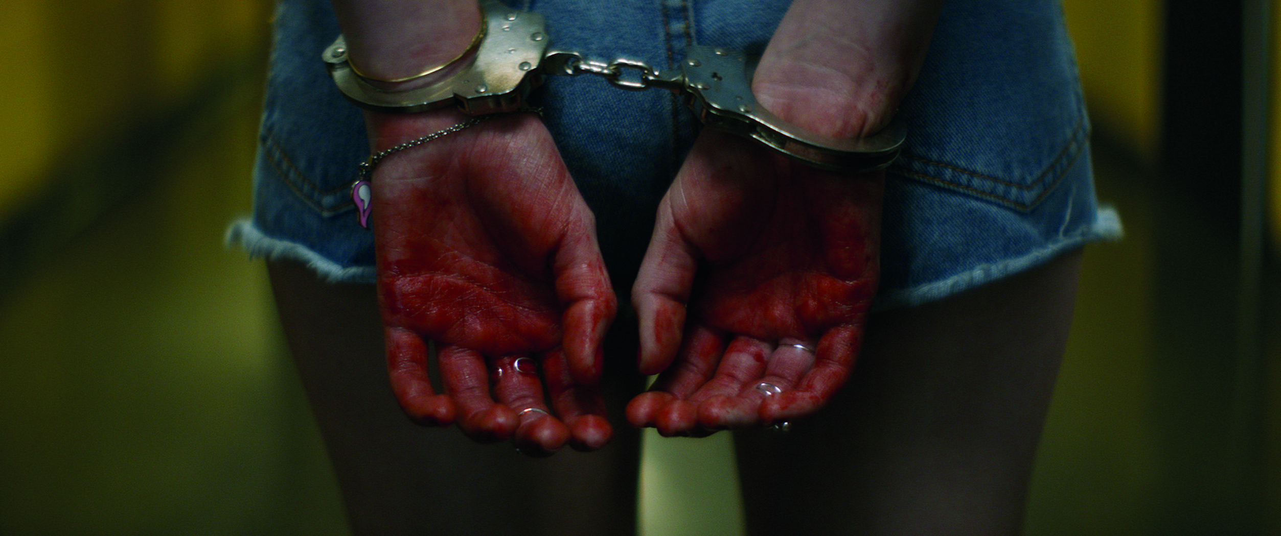 Zakrwawione dłonie skute w kajdankach. Assassination Nation/mat. prasowe