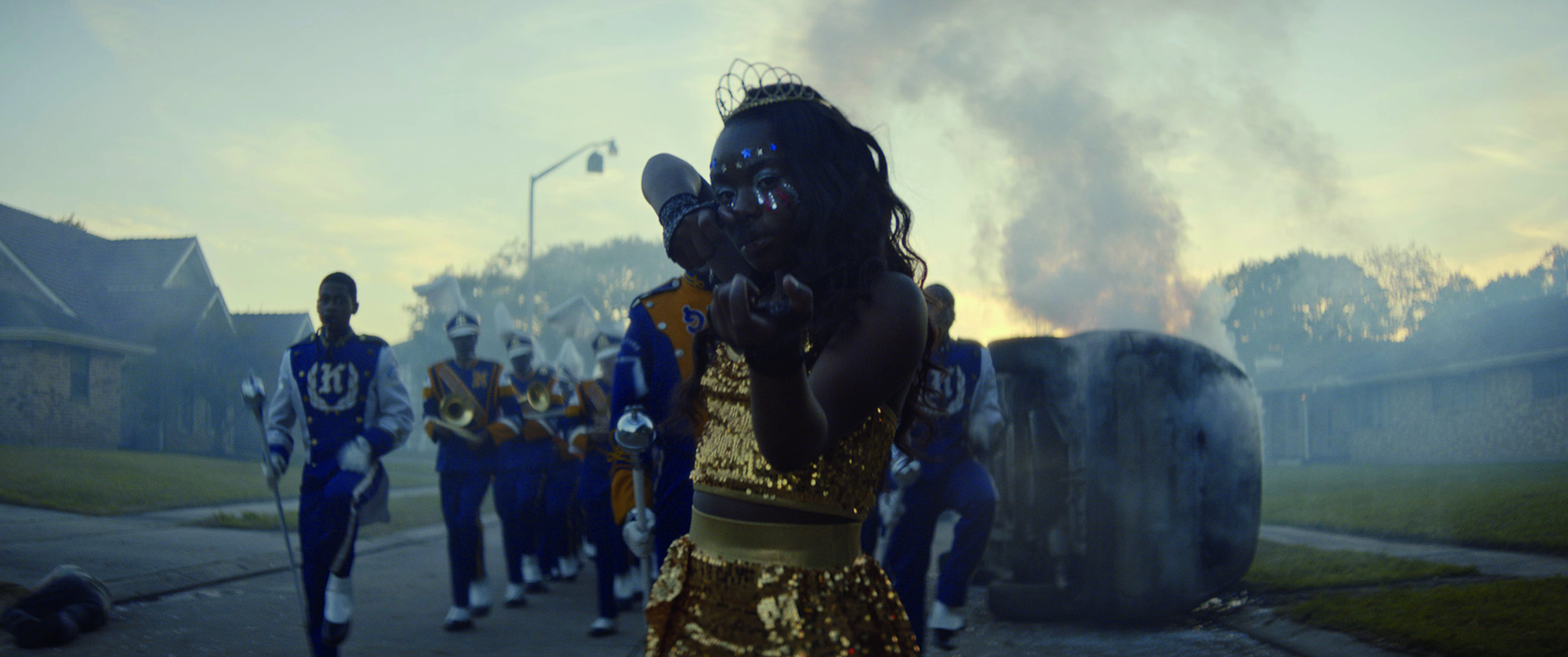 Cheerleaderka udaje, że trzyma broń i mierzy w aparat.