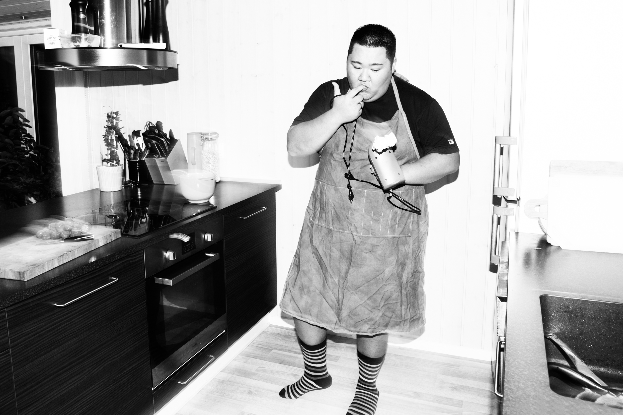 Micki står i køkkenet og slikker sig på fingrene