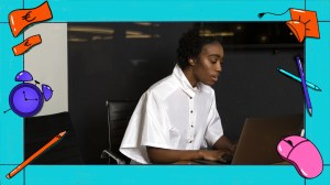 Een jong non-binair persoon werkt achter een laptop.