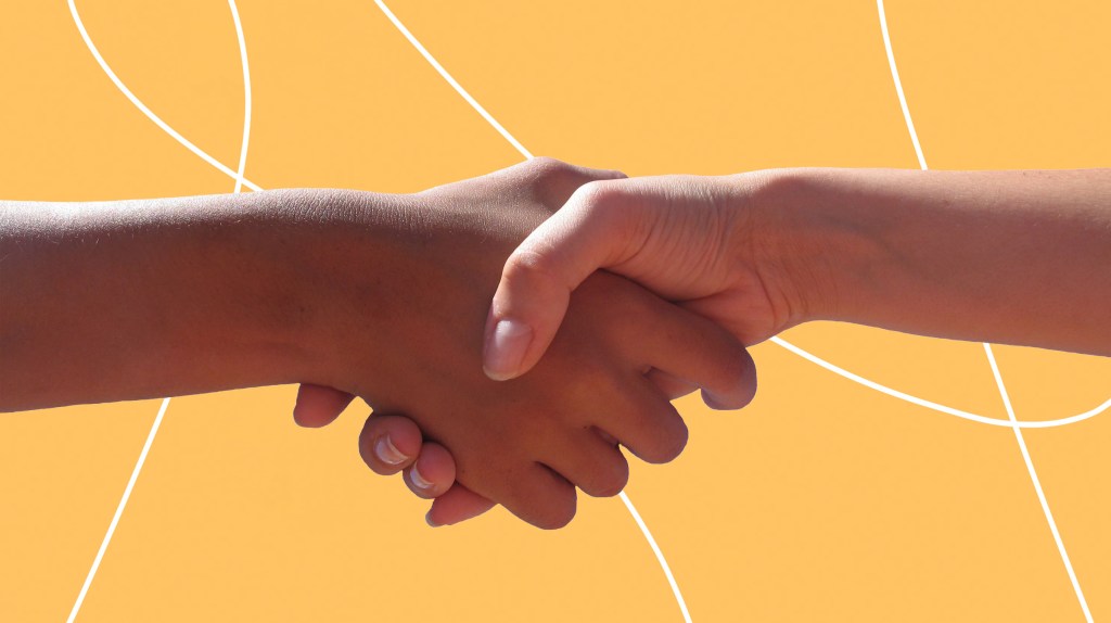 Zwei Menschen geben sich die Hand