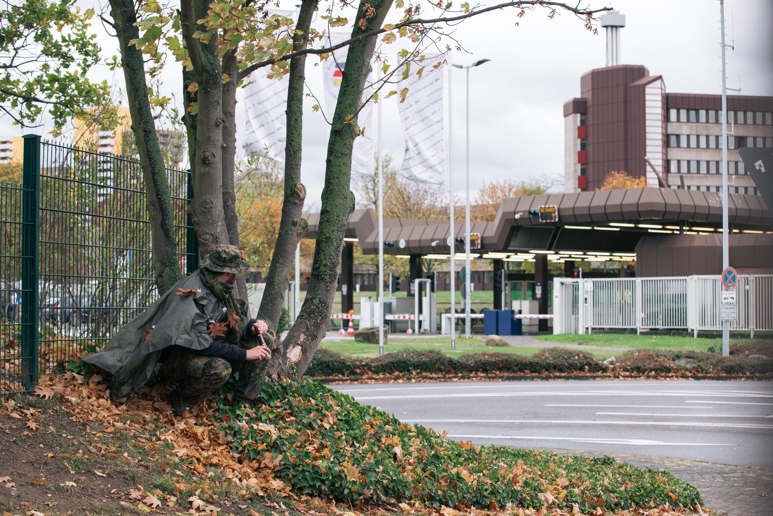 Der Autor kauert an einem Hügel und beobachtet den Eingang zum Bundesamt für Verfassungsschutz