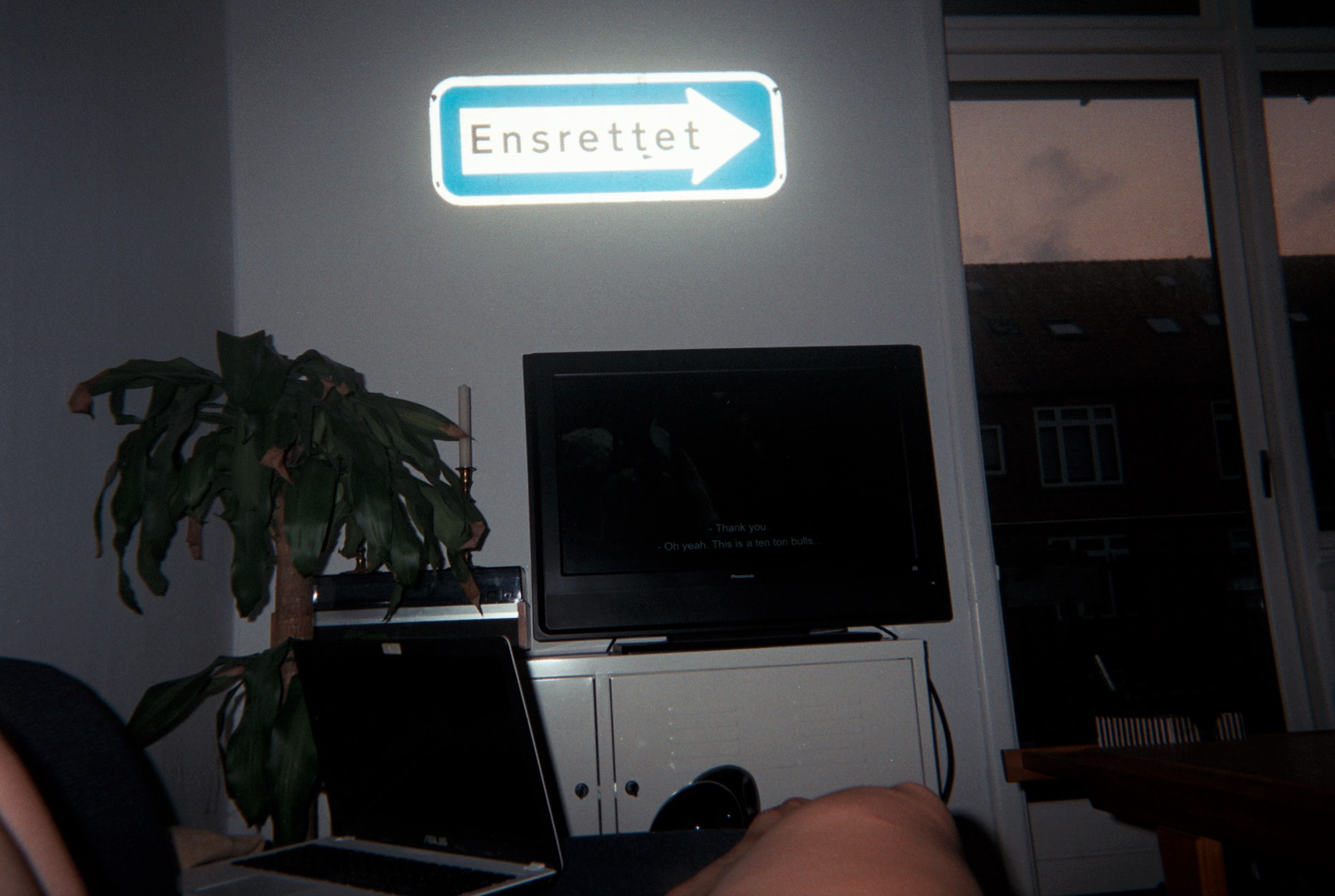 Man kan se benene på en person, der ligger foran et tv