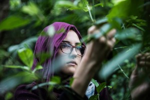Foto de uma mulher com lenço na cabeça perto de plantas