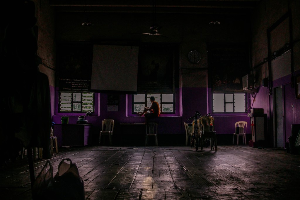 Penghuni Gedung Setan di Surabaya memandangi jendela.