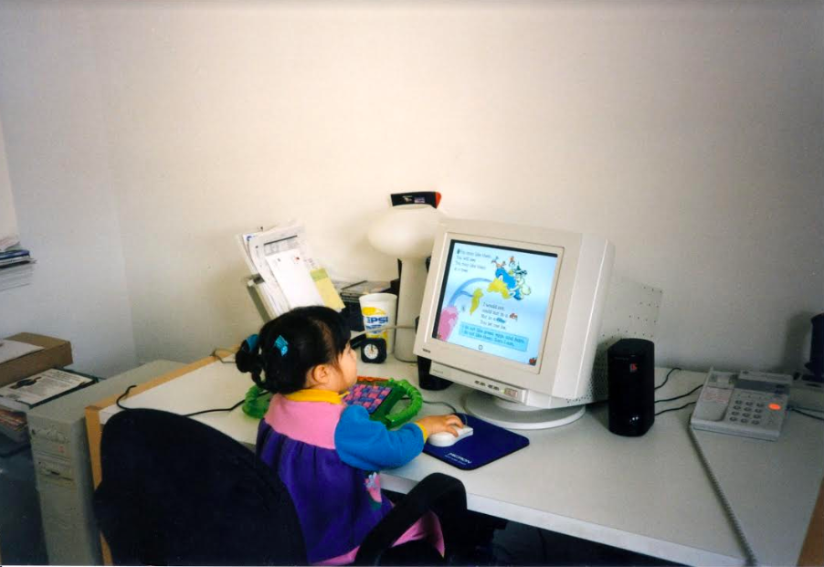 Childhood photo of writer sitting at desk playing computer games