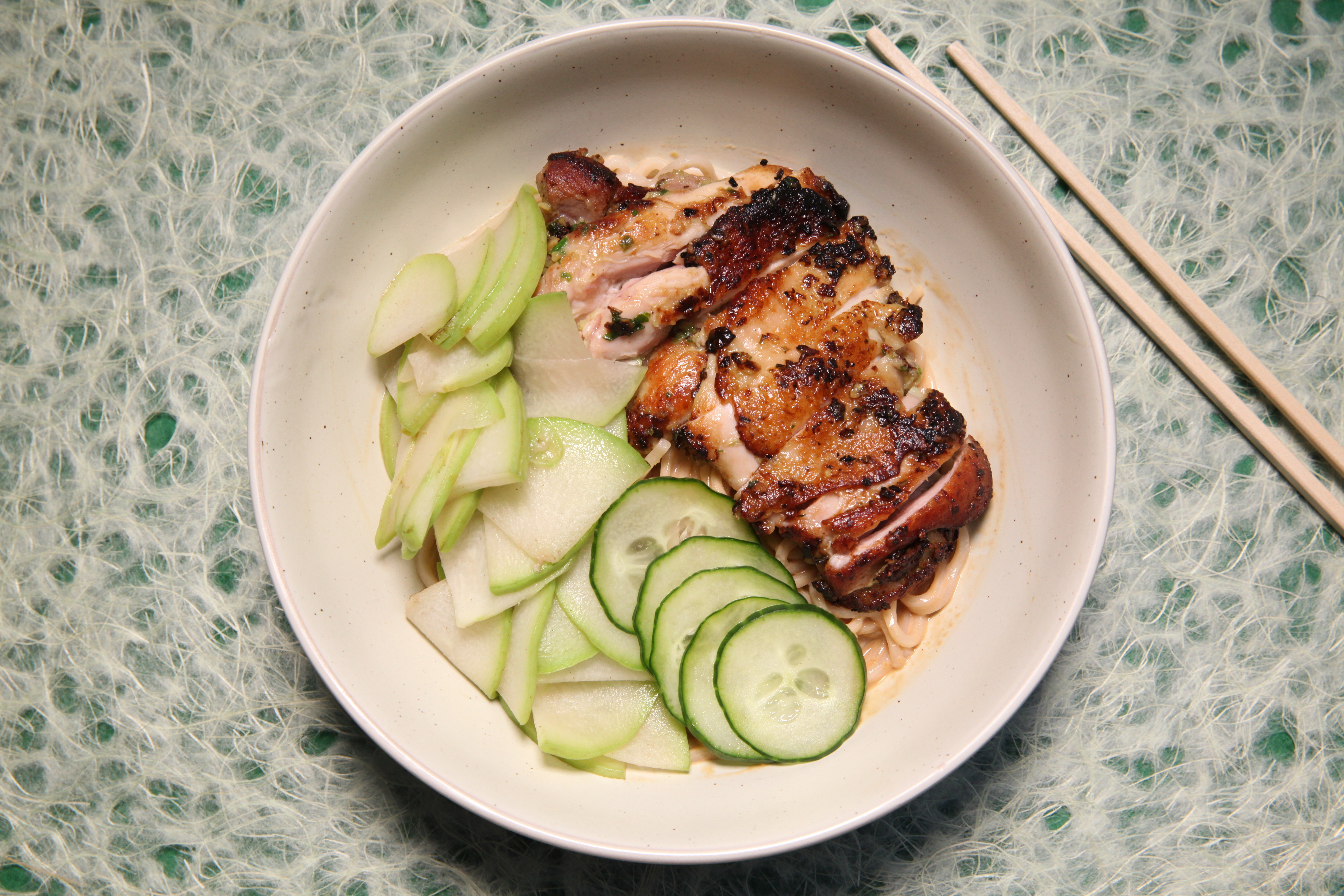 a noodle bowl from junzi kitchen with sesame furu sauce, seared chicken thighs, chayote, and cucumber