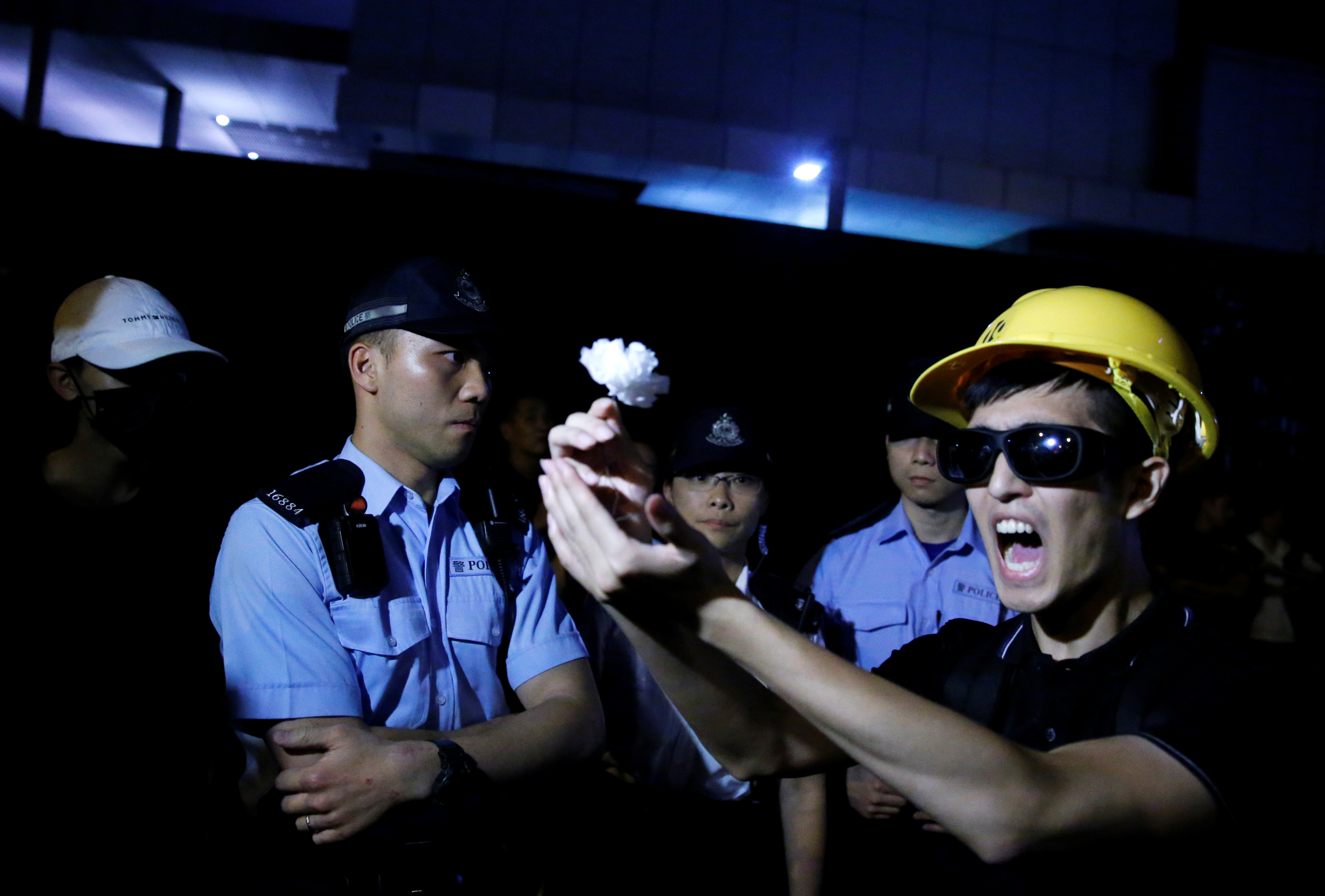A protester reacts after he tried to offer a white flower to police officers.
