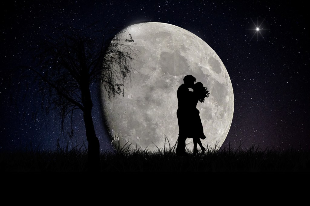 two people kissing in front of the giant and beautiful moon