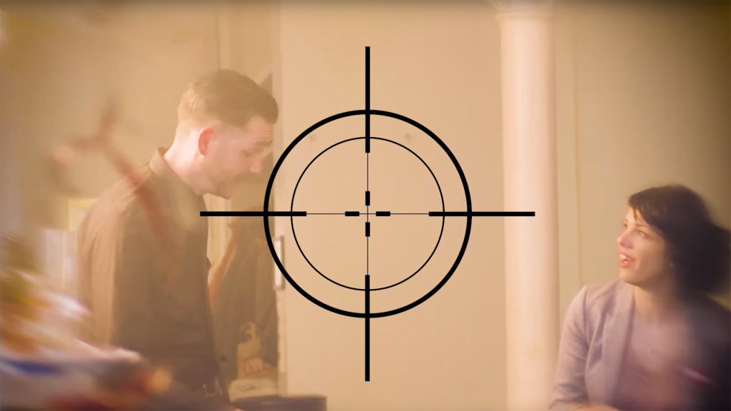 Screenshot aus dem Video, ein Fadenkreuz vor zwei Menschen