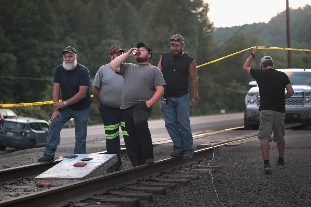 Coal miners from Blackjewel coal company pass time playing cornhole on the railroad tracks that lead to one of the company's mines on August 08, 2019 near Cumberland, Kentucky. (Photo by Scott Olson/Getty Images)