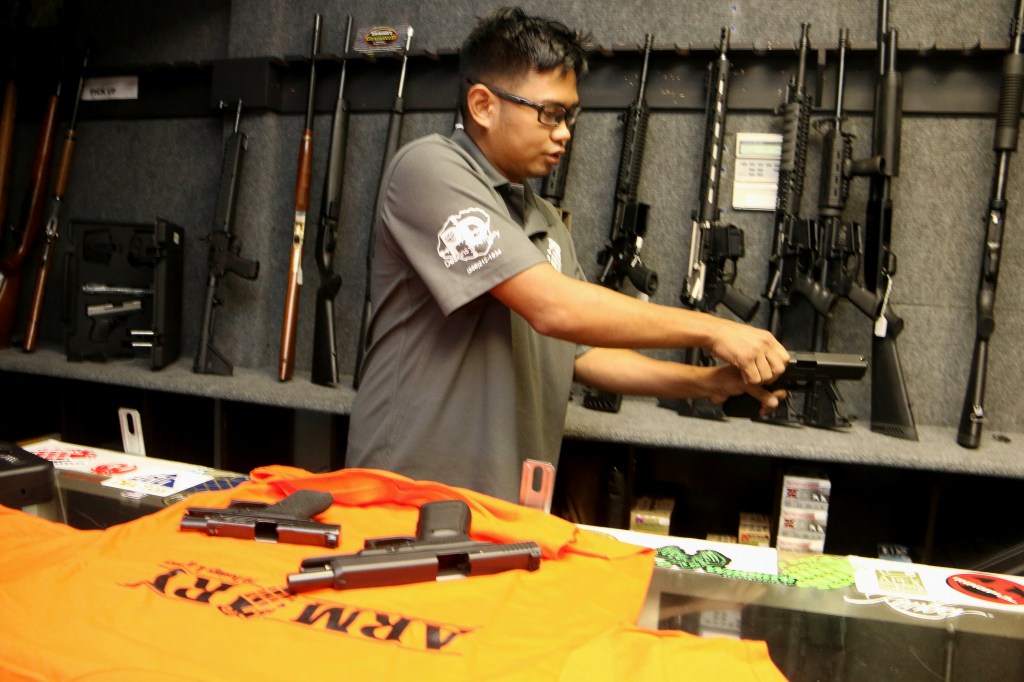 A police officer inspects a gun.