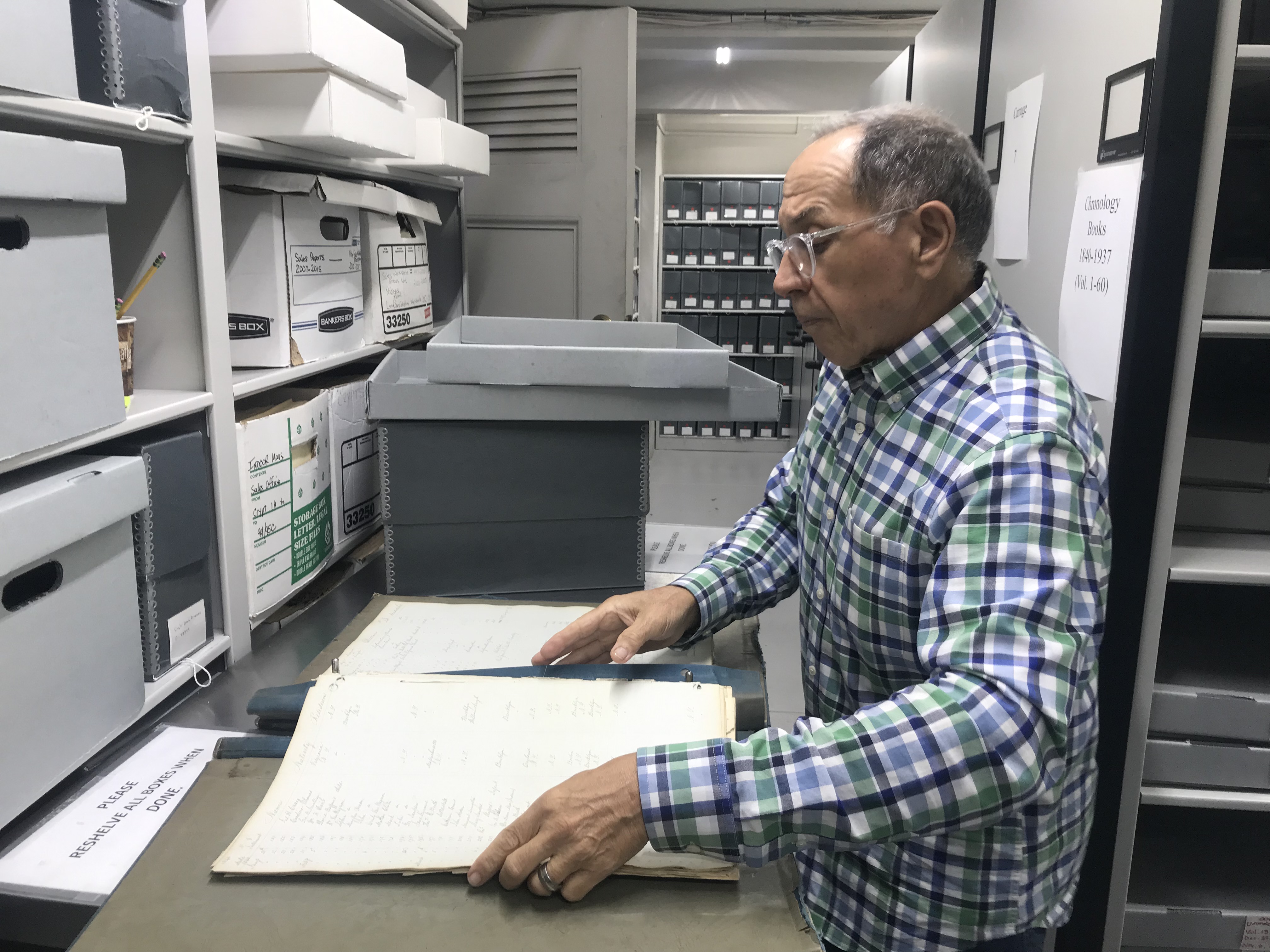 Tony Cucchiara opens a chronology book at the Green-Wood Cemetery archives. Taken by Caroline Haskins.