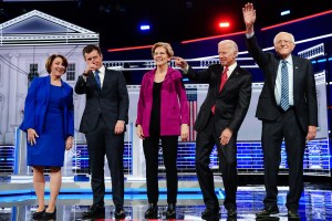Democratic presidential candidates wave to the crowd from the debate stage.