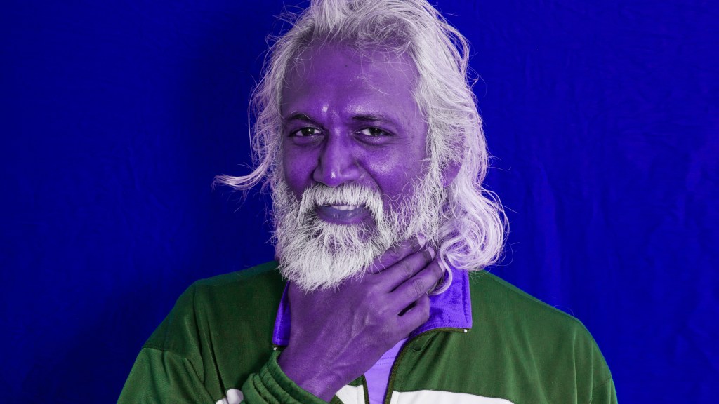 Lächelnder älterer Mann mit lilafarbenem Gesicht