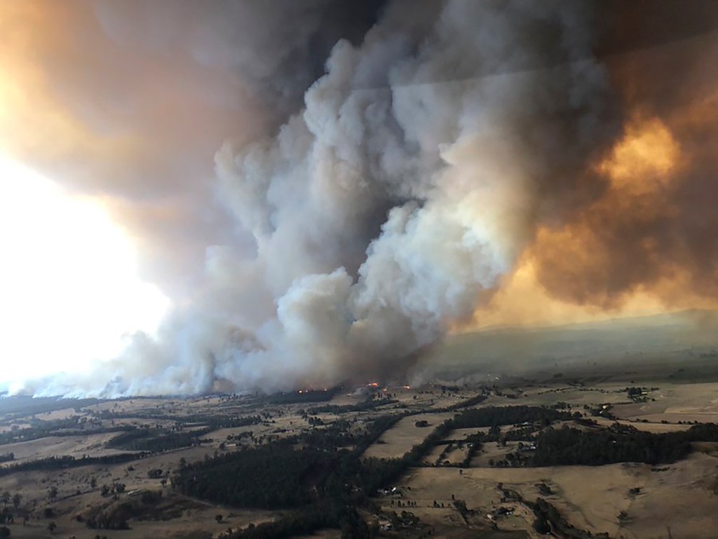 wildfires rage under plumes of smoke in Bairnsdale, Australia. Thousands of tourists fled Australia's wildfire-ravaged eastern coast