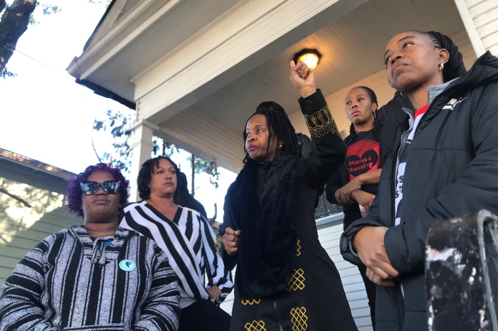 Sharena Thomas, left, Carroll Fife, center, Dominique Walker, second from right, and Tolani KIng, right, stand outside a vacant home on Magnolia Street in West Oakland, Calif. The group Moms 4 Housing is fighting an eviction after occupying the house sinc