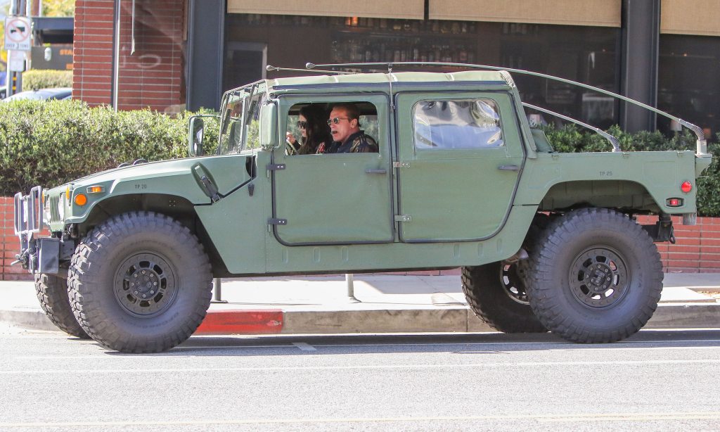 Arnold Schwarzenegger in a Hummer smoking a cigar
