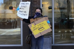 A protester holding a sign demanding improved working conditions at Whole Foods.