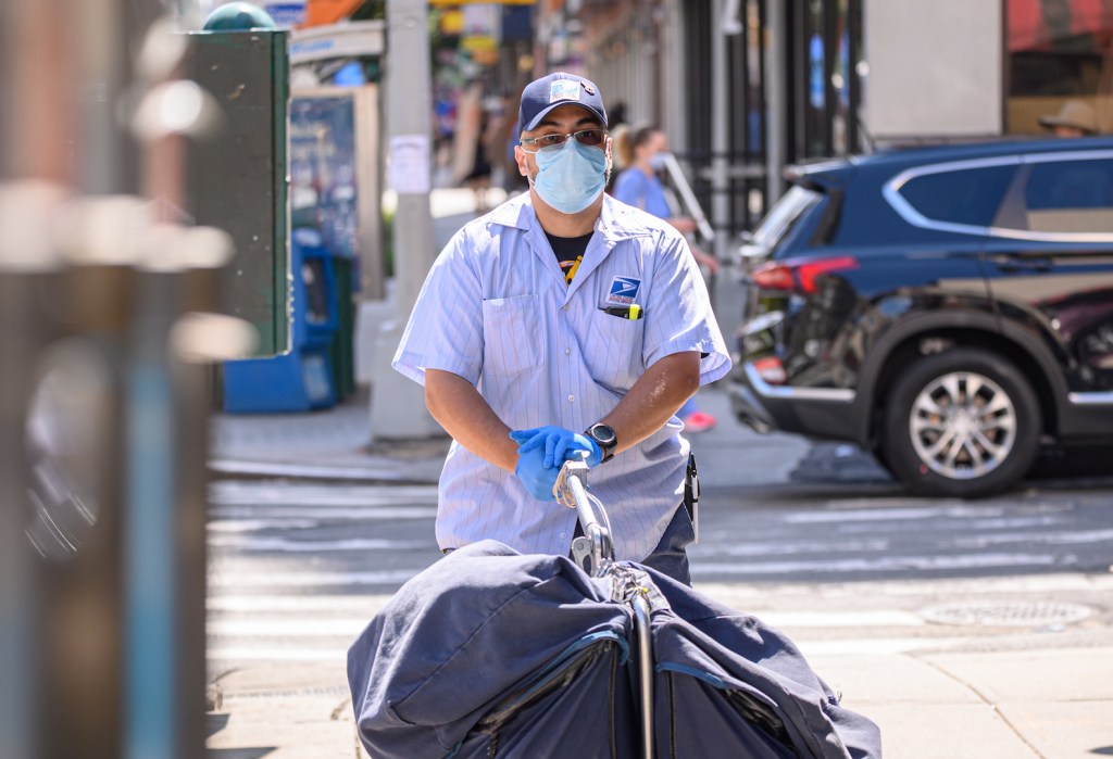 A USPS worker wheels mail in Kips Bay on August 18, 2020 in New York City.