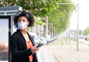 Mujer joven con mascarilla protectora al aire libre