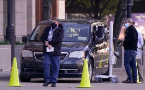 Election officials stand by as a voter uses a rolling voting machine in the drive-up lane outside the American Airlines Center in downtown Dallas on Tuesday, Nov. 3, 2020, in Dallas. (AP Photo/LM Otero)​