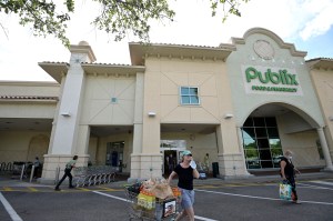 Customers walk through the parking lot after shopping at a Publix grocery store, Thursday, May 14, 2020, in Orlando, Fla. Grocery stores are among the essential businesses remaining open during the new coronavirus pandemic.