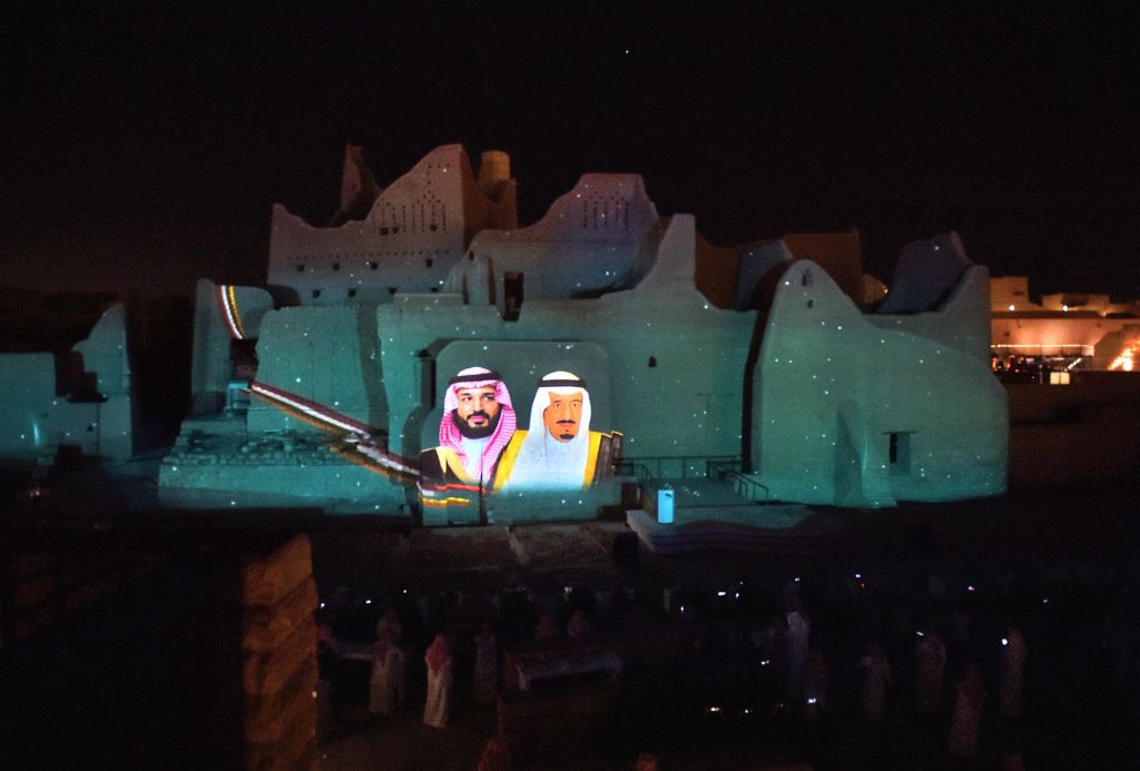 A picture of Saudi King Salman bin Abdulaziz (and his son Crown Prince Mohammed bin Salman is projected at the historical site of al-Tarif in Diriyah district, on the outskirts of Saudi capital Riyadh, on November 20, 2020. Photo: FAYEZ NURELDINE / AFP)
