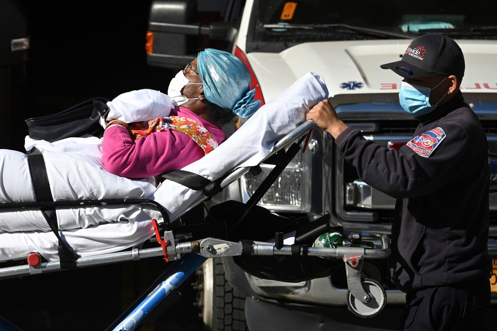 A woman lying on a stretcher is wheeled out of Wyckoff Heights Medical Center in the Queens borough of New York City, NY, November 10, 2020. (Anthony Behar/Sipa USA)(Sipa via AP Images)