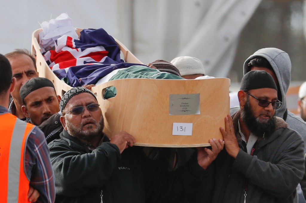 Mourners carry the body of a victim of the March 15 mosque shootings for a burial at the Memorial Park Cemetery in Christchurch, New Zealand, Friday, March 22, 2019. (AP Photo/Vincent Thian)