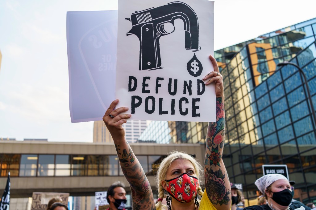 A Protester hold a sign reading "Defund the Police" outside Hennepin County Government Plaza during a demonstration against police brutality and racism on August 24, 2020 in Minneapolis, Minnesota.