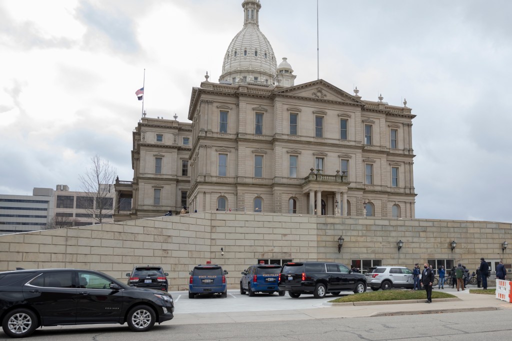 Governor Gretchen Whitmer is escorted to the entrance of the Michigan State Capitol on December 14, 2020 in Lansing, Michigan. Michigan electors will meet this afternoon to certify the electoral college vote.