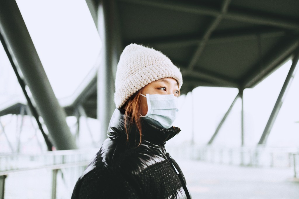 Young Asian woman wearing a mask at city street, Shanghai, China