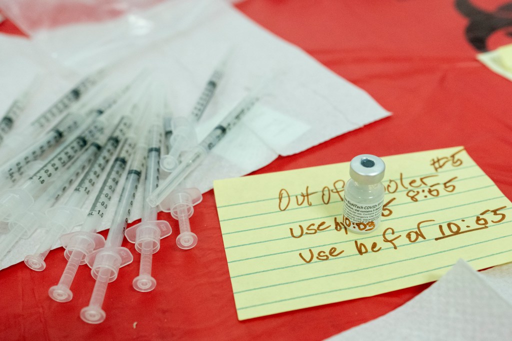 A Pfizer-BioNTech COVID-19 Vaccine vial is seen marked with the time it left the cooler next to syringes loaded with the vaccine at a pop-up COVID-19 vaccination site at St. Luke's Episcopal Church, Tuesday, Jan. 26, 2021, in the Bronx borough of New York
