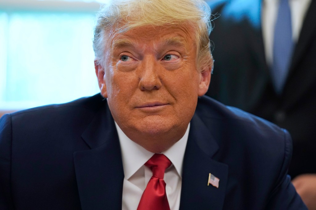 President Donald Trump listens while on a phone call with the leaders of Sudan and Israel, in the Oval Office of the White House, Friday, Oct. 23, 2020, in Washington.