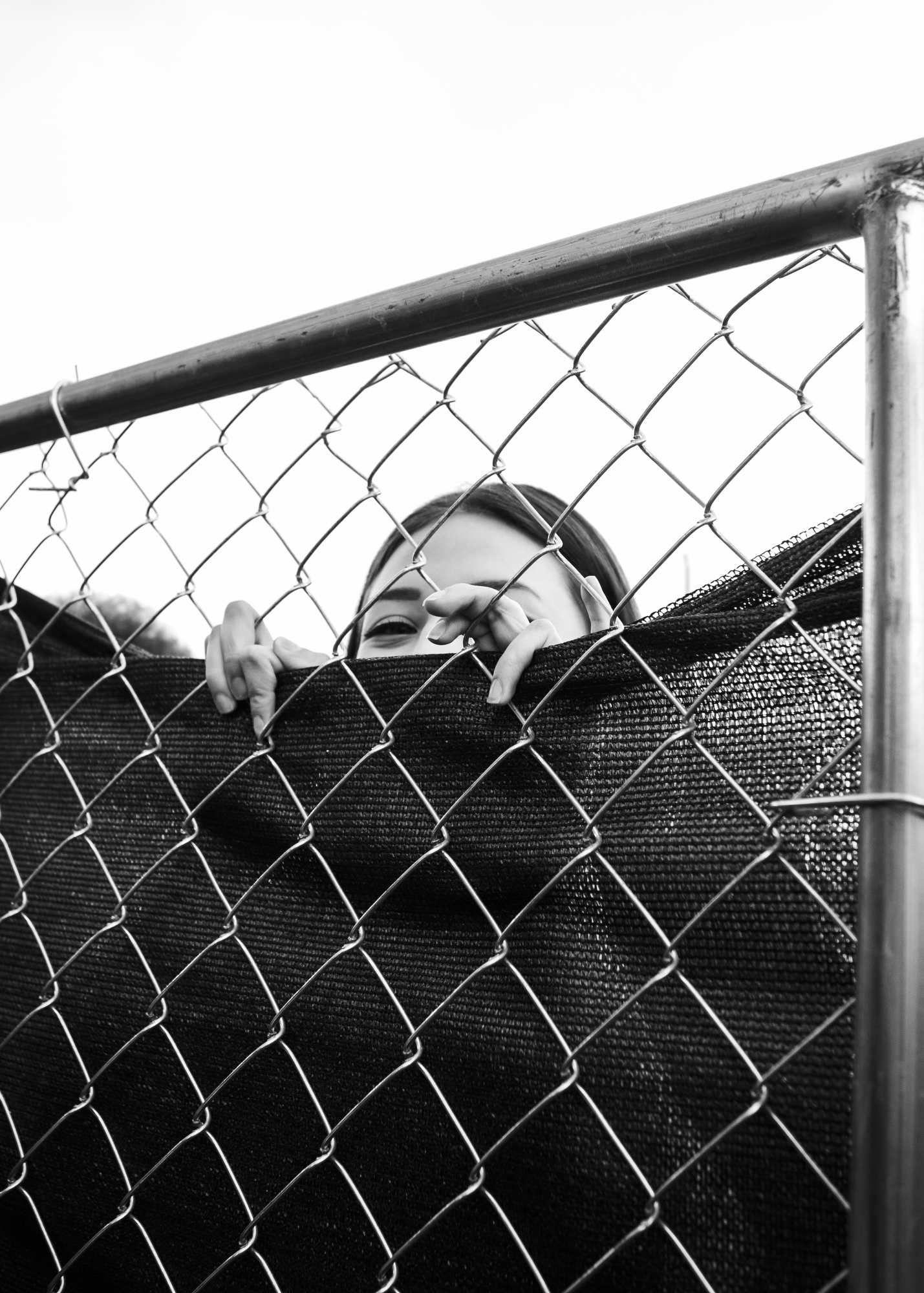 A fan peeking through a fence.