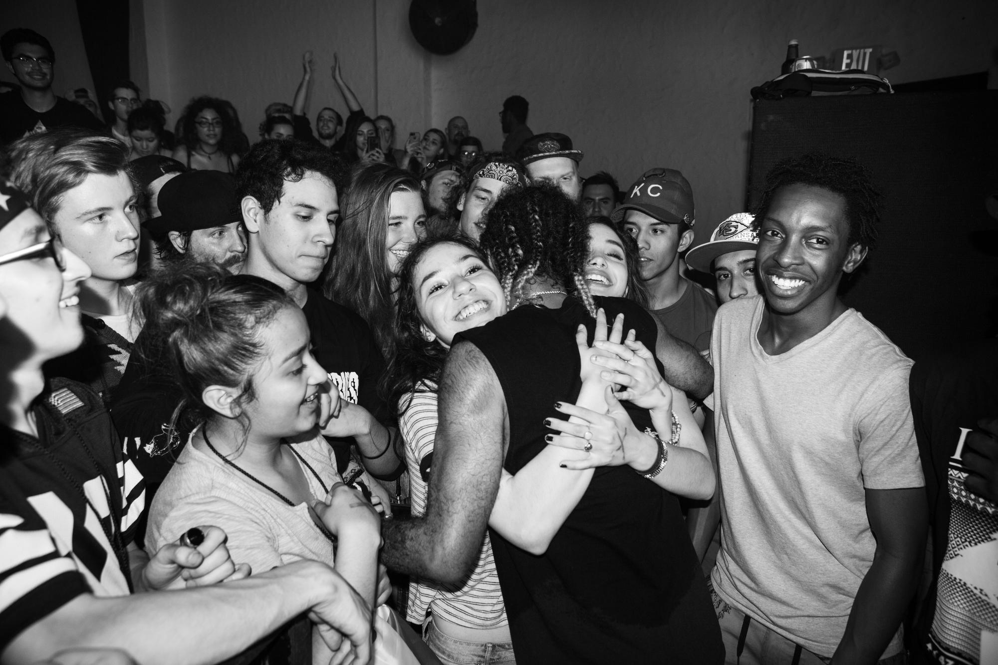 One fan embraces a rapper as other watch in admiration.