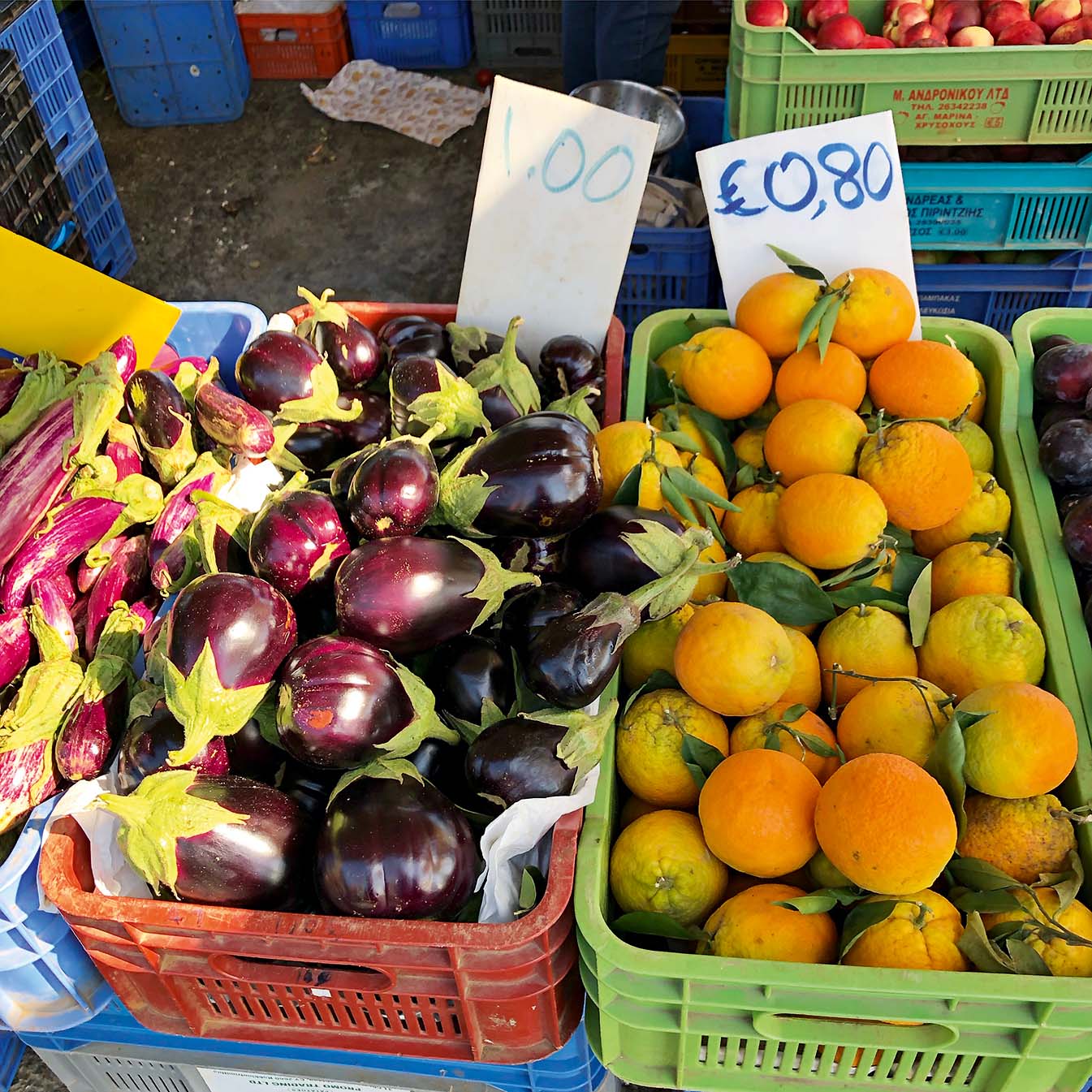 Aubergine and oranges on a market stall.