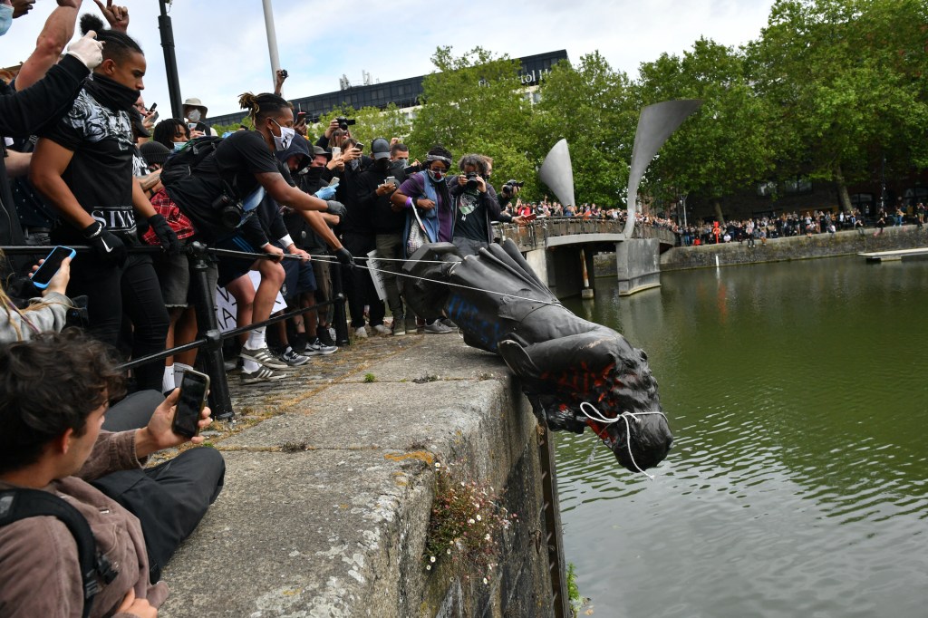 Protesters throw a statue of slave trader Edward Colston into Bristol Harbour in the U.K. during a Black Lives Matter protest rally last June