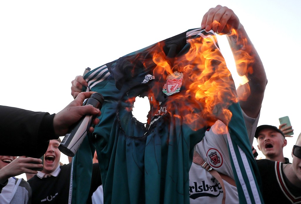 Fans burn a Liverpool replica shirt outside Elland Road against Liverpool's decision to be included amongst the clubs attempting to form a new European Super League. Photo by Zac Goodwin/PA Images via Getty Images