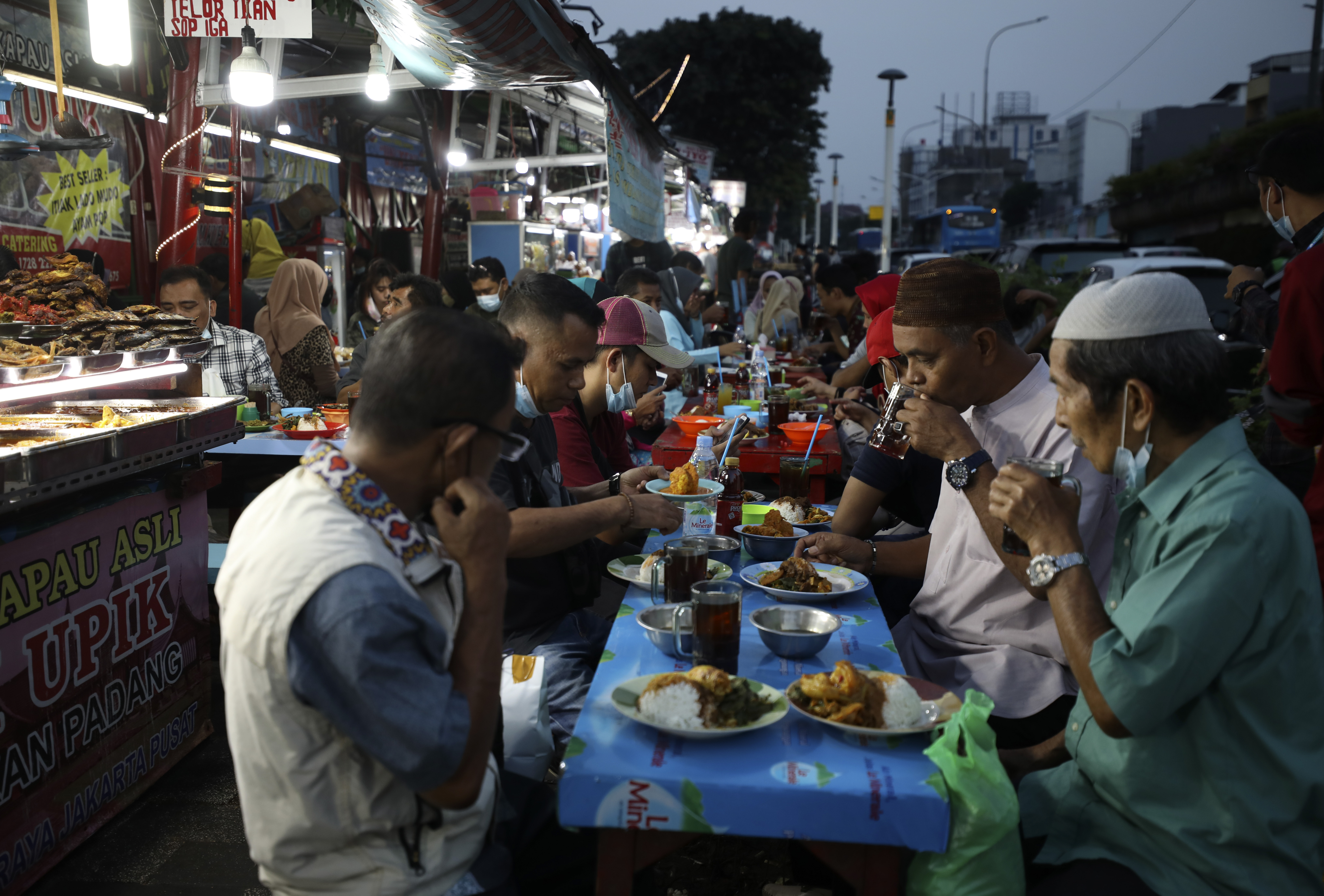 Men have an iftar meal to break their fast during the second week of Ramadan, at a roadside eatery in Jakarta, Indonesia. Photo: AP/Dita Alangkara