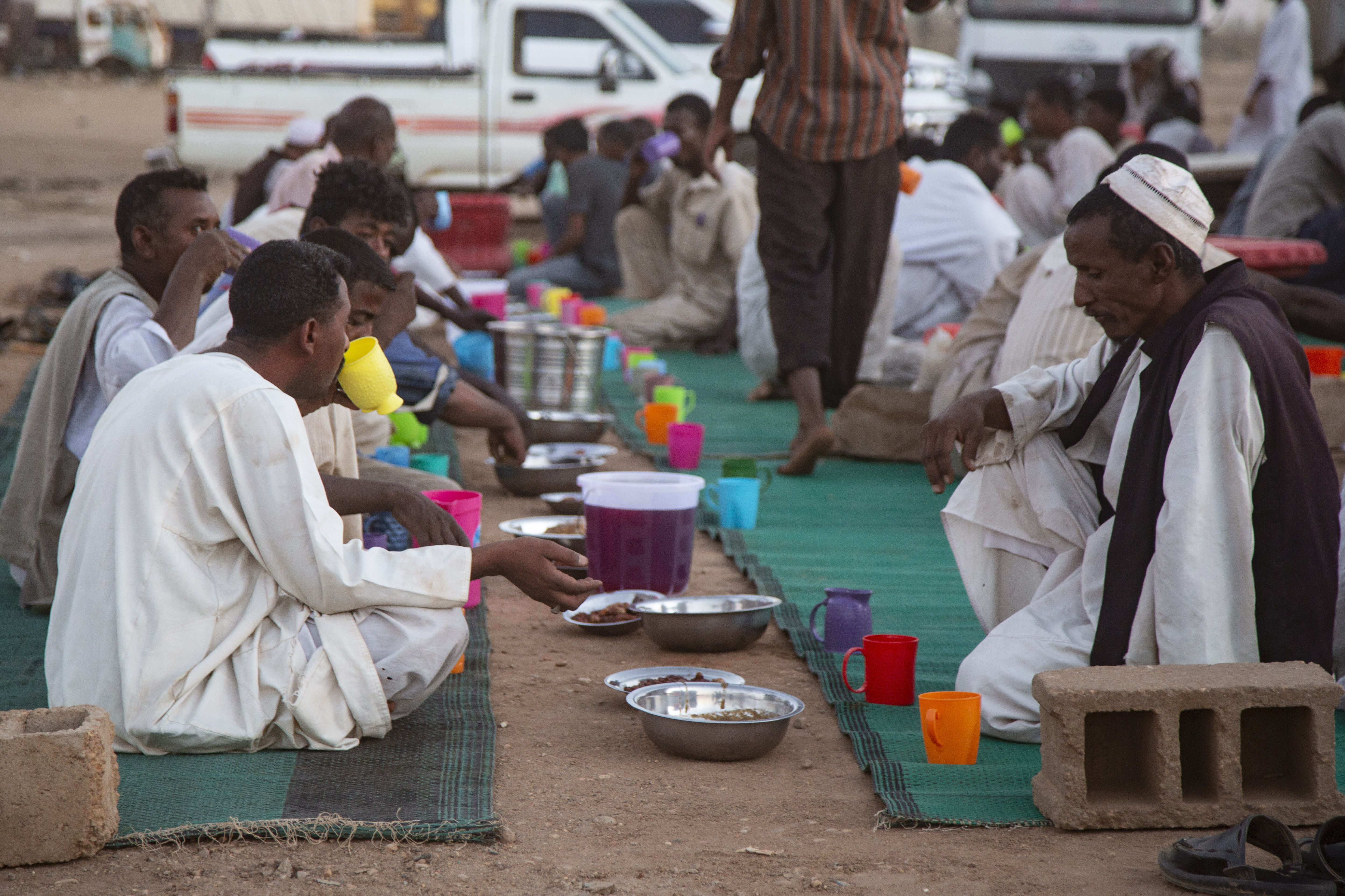 People break their fast in Khartoum, Sudan at tables set by the road. Photo: Mahmoud Hjaj/Anadolu Agency via Getty Images